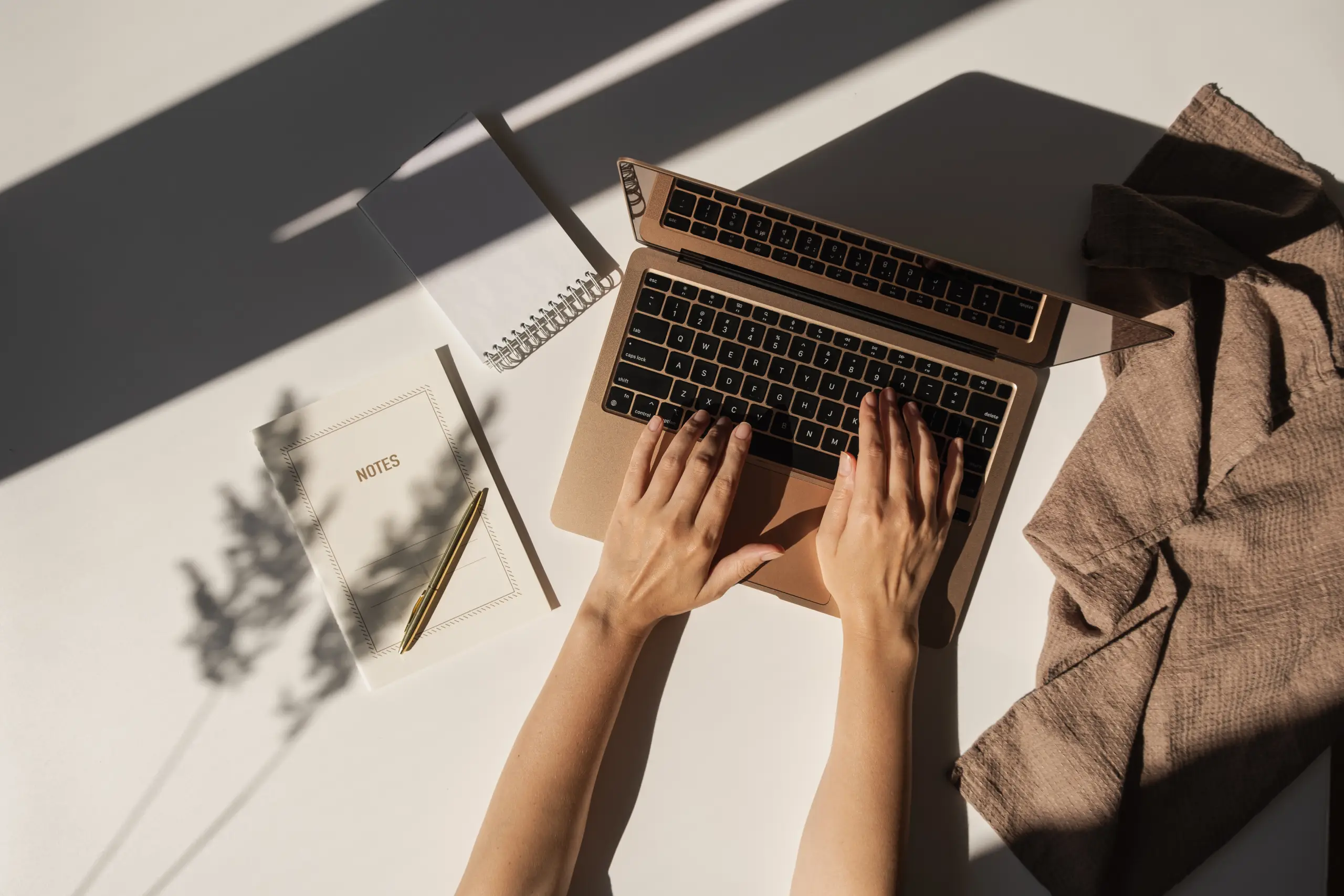 aesthetic-luxury-bohemian-minimalist-home-office-workspace-desk-woman-working-laptop-computer-notebook-blanket-pampas-grass-with-sunlight-shadows-flat-lay-top-view-work-business-concept